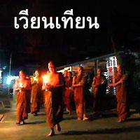 Luang Pu Uthai Siridharo lead walk with lighted candles in hand around a temple 